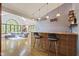 A well-lit bar area featuring tile accents, shelving, and hardwood floors at 7426 Shadow Wood Dr, Indianapolis, IN 46254