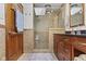 Bathroom with wood cabinets, tiled shower and glass doors at 7426 Shadow Wood Dr, Indianapolis, IN 46254