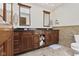 Bathroom with wood cabinets, double sinks, mirrors and dark countertops at 7426 Shadow Wood Dr, Indianapolis, IN 46254