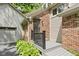 Close-up of front entry with a brick facade, gray siding, and landscaped plants at 7426 Shadow Wood Dr, Indianapolis, IN 46254