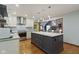 A modern kitchen island with granite countertops, stainless steel appliances, and gray lower cabinets at 7426 Shadow Wood Dr, Indianapolis, IN 46254