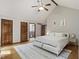 Hardwood floors, white decor and vaulted ceiling highlight this modern bedroom with multiple doors and white area rug at 7426 Shadow Wood Dr, Indianapolis, IN 46254