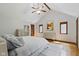 Vaulted ceilings, exposed beams, and hardwood floors accent this comfortable bedroom with light grey decor at 7426 Shadow Wood Dr, Indianapolis, IN 46254