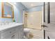 Bathroom featuring a tub-shower combo, single sink vanity, and oak framed mirror at 7630 Blain Way, Indianapolis, IN 46254