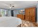 Comfortable bedroom with hardwood floors, large dressers, and a wall-mounted television at 7630 Blain Way, Indianapolis, IN 46254