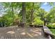 Large wooden deck surrounded by mature trees features built-in benches, offering a great space for outdoor relaxation at 7630 Blain Way, Indianapolis, IN 46254