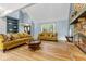 Living room featuring hardwood floors, vaulted ceiling, stone fireplace, and built-in shelving at 7630 Blain Way, Indianapolis, IN 46254