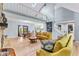 Spacious living room with a stone fireplace, vaulted ceiling, and hardwood floors open to dining area at 7630 Blain Way, Indianapolis, IN 46254