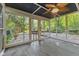 An enclosed porch offers an airy feel with its screened walls, fan, and views of the surrounding lush greenery at 7630 Blain Way, Indianapolis, IN 46254