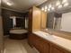 A bathroom features a large mirror, jacuzzi tub, vanity, and linen closet at 802 Fern Dr, Shelbyville, IN 46176