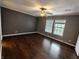 A bedroom featuring hardwood floors, neutral walls, large windows, and ceiling fan at 802 Fern Dr, Shelbyville, IN 46176