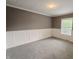 Comfortable bedroom featuring gray carpet, white wainscoting, and a window providing natural light at 802 Fern Dr, Shelbyville, IN 46176