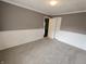 Comfortable bedroom featuring gray carpet, white wainscoting, and a window providing natural light at 802 Fern Dr, Shelbyville, IN 46176