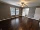 Bedroom with hardwood floors, fan, closet, and ample natural light from two windows at 802 Fern Dr, Shelbyville, IN 46176