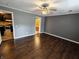 Bedroom with hardwood floors and neutral gray walls open to a bathroom and kitchen at 802 Fern Dr, Shelbyville, IN 46176