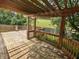 Wooden deck showcasing pergola, railing and view of a grassy yard with white fence at 802 Fern Dr, Shelbyville, IN 46176