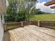 Wooden deck with railings showcasing an expansive backyard with grassy hill and trees at 802 Fern Dr, Shelbyville, IN 46176
