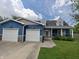 Charming blue two-story home with a landscaped front yard and an attached two-car garage at 802 Fern Dr, Shelbyville, IN 46176