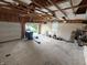 Spacious garage featuring bare walls, exposed ceiling rafters, and a garage door at 802 Fern Dr, Shelbyville, IN 46176