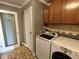 Functional laundry room with modern front load appliances and overhead cabinet storage at 802 Fern Dr, Shelbyville, IN 46176