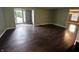 Spacious living room featuring gleaming hardwood floors and ample natural light through sliding glass doors at 802 Fern Dr, Shelbyville, IN 46176