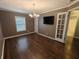 Well lit living room area featuring hardwood floors, TV, French doors, and window with blinds at 802 Fern Dr, Shelbyville, IN 46176