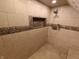 Tiled shower stall featuring a mosaic tile accent, shower head, and built-in niche at 802 Fern Dr, Shelbyville, IN 46176