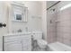 Well-lit bathroom featuring a shower with neutral tile, white vanity, and modern fixtures at 8205 Picadilly Ln, Indianapolis, IN 46256