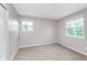 Well-lit bedroom featuring neutral walls, soft carpet, and multiple bright windows at 8205 Picadilly Ln, Indianapolis, IN 46256