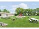 Open common area with picnic tables, benches, a playground, and a fire pit for resident enjoyment at 8205 Picadilly Ln, Indianapolis, IN 46256