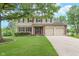 Inviting two-story home with a well-manicured lawn, mature tree, and a two-car garage at 8205 Picadilly Ln, Indianapolis, IN 46256
