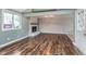 Bright open-concept living room features a fireplace, hardwood floors, and door to the outside at 8205 Picadilly Ln, Indianapolis, IN 46256