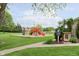 Community playground with multiple slides and climbing structures on a well-maintained green lawn at 8205 Picadilly Ln, Indianapolis, IN 46256