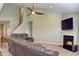 Cozy living room with a fireplace, TV, ceiling fan, and comfortable gray leather seating for a relaxing atmosphere at 925 Bent Branch Cir, Greenwood, IN 46143