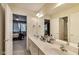 Bathroom featuring a double sink vanity, a large mirror, and doorway to adjacent rooms at 9698 Coyote Ct, Noblesville, IN 46060