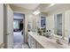 Bathroom featuring a double sink vanity, large mirror, and doorway to an adjacent room at 9698 Coyote Ct, Noblesville, IN 46060