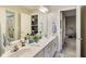 Bright bathroom with double sink vanity, large mirror, and doorway to adjoining bedroom at 9698 Coyote Ct, Noblesville, IN 46060
