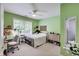 Bedroom featuring a window, green walls, and a ceiling fan at 9698 Coyote Ct, Noblesville, IN 46060