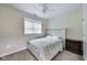 Bright bedroom with a white tufted headboard, ceiling fan, and window for natural light at 9698 Coyote Ct, Noblesville, IN 46060