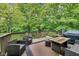 Outdoor deck with comfortable seating, a grill, and views of the lush, surrounding trees at 9698 Coyote Ct, Noblesville, IN 46060