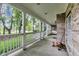 Expansive front porch with brick walls, white columns, and ample seating, providing a great space for relaxation at 9698 Coyote Ct, Noblesville, IN 46060