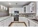Bright kitchen with white cabinets, granite countertops, and stainless steel appliances, offering ample counter space at 9698 Coyote Ct, Noblesville, IN 46060