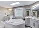 Bright main bathroom featuring a soaking tub, dual sink vanities, and large mirror at 9698 Coyote Ct, Noblesville, IN 46060