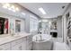 Large main bathroom featuring a soaking tub, dual sink vanities, and decorative fixtures at 9698 Coyote Ct, Noblesville, IN 46060