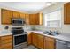 Kitchen featuring oak cabinets, stainless steel appliances, and a double sink at 1024 Rotherham Ln, Beech Grove, IN 46107