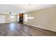 Spacious living room featuring a brick fireplace, wood-look flooring, and a modern chandelier at 1024 Rotherham Ln, Beech Grove, IN 46107