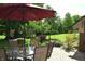 Scenic backyard view with a covered patio, lush lawn, shade trees, and beautiful landscaping at 1065 Lakewood South Dr, Brownsburg, IN 46112