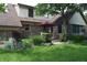 Beautiful backyard with a covered patio, brick exterior, lush lawn, and mature trees at 1065 Lakewood South Dr, Brownsburg, IN 46112