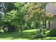 Beautiful backyard featuring mature trees, landscaping, and a well-maintained lawn at 1065 Lakewood South Dr, Brownsburg, IN 46112