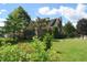 Large backyard showcasing mature trees, lush green lawn, vinyl siding, and brick, creating a serene outdoor space at 1065 Lakewood South Dr, Brownsburg, IN 46112